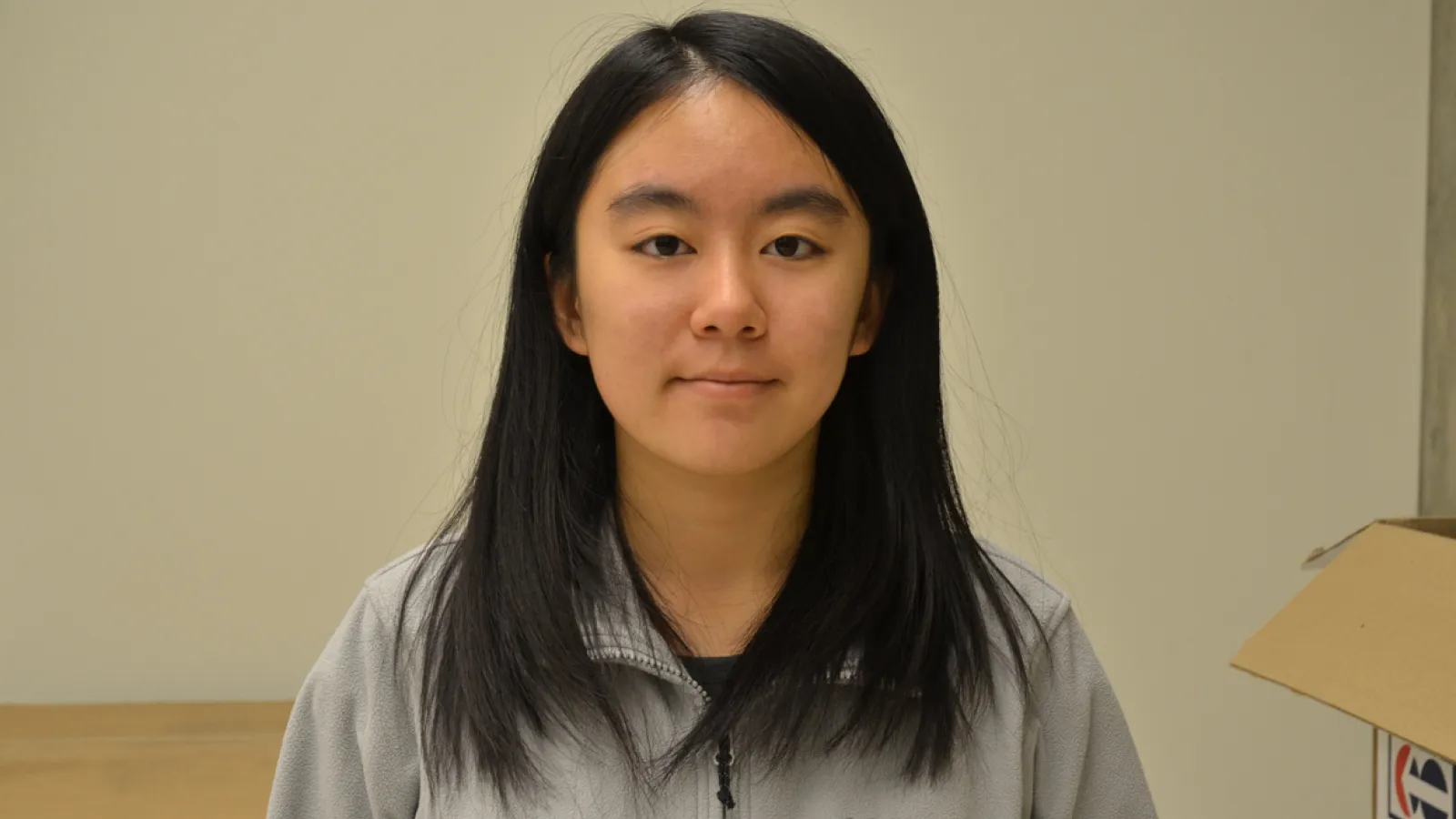 Kelly Luo standing in front of blank wall