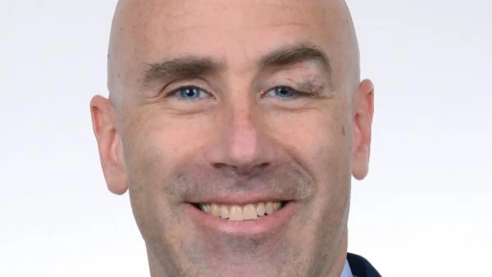 Professor Poirier smiling with a white background