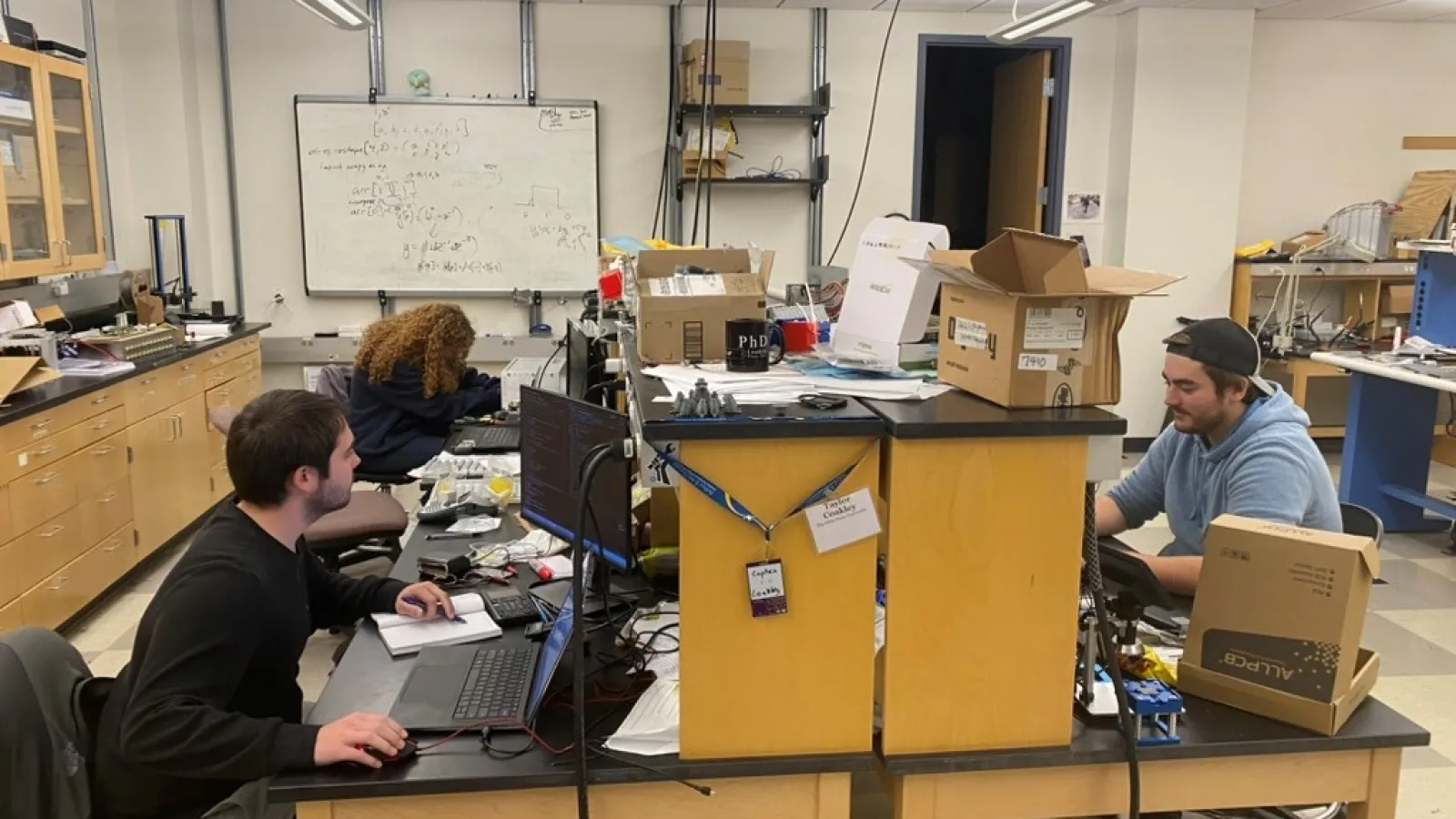 Three students in Beatty/Connolly Lab working at desks.