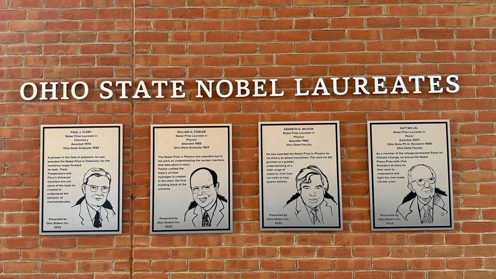Brick wall with silver plaques of four Ohio State Nobel Laureates