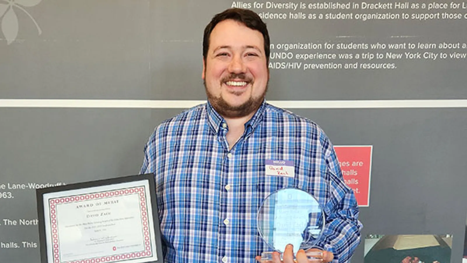 David Zach holding his certificate and award