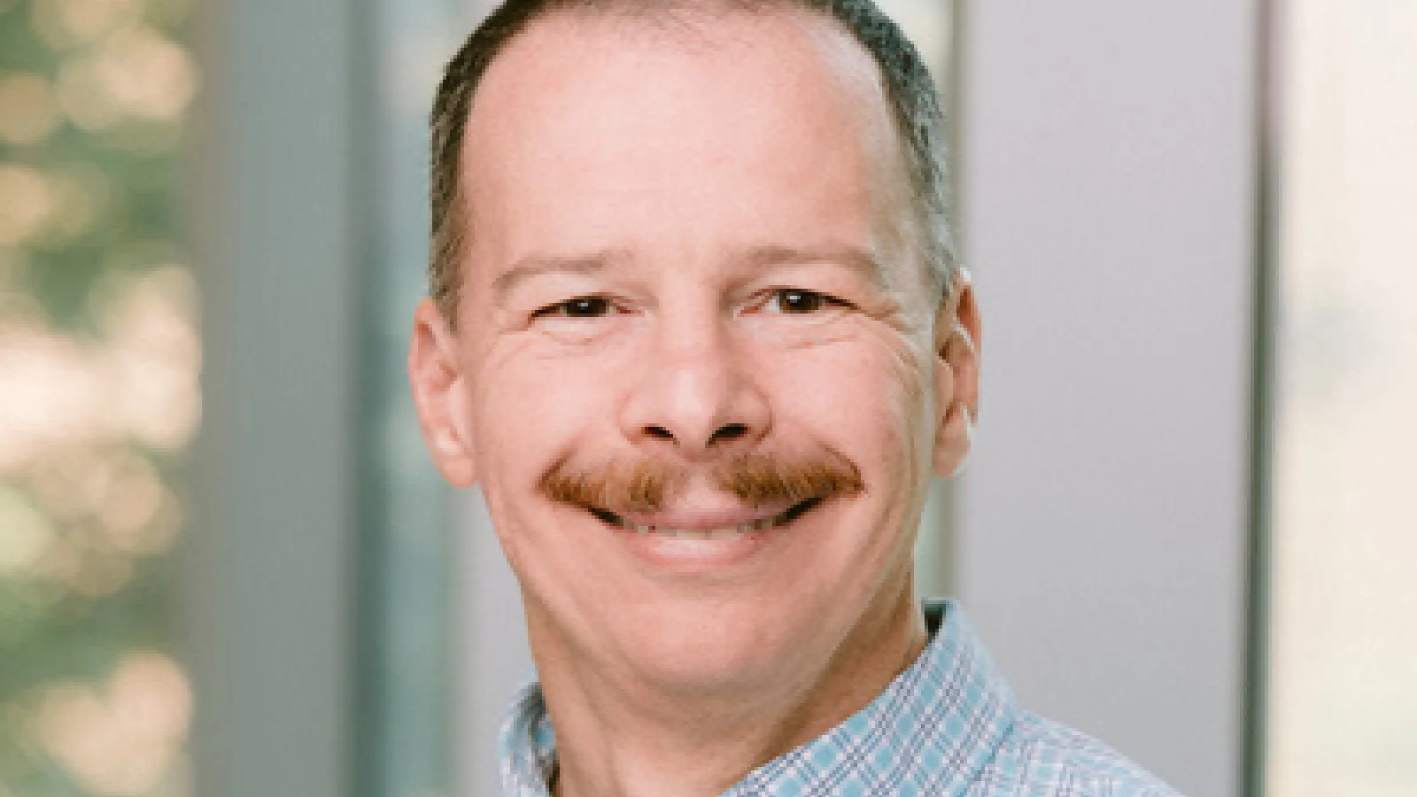 Professor Kovchegov headshot with blurry window in the background