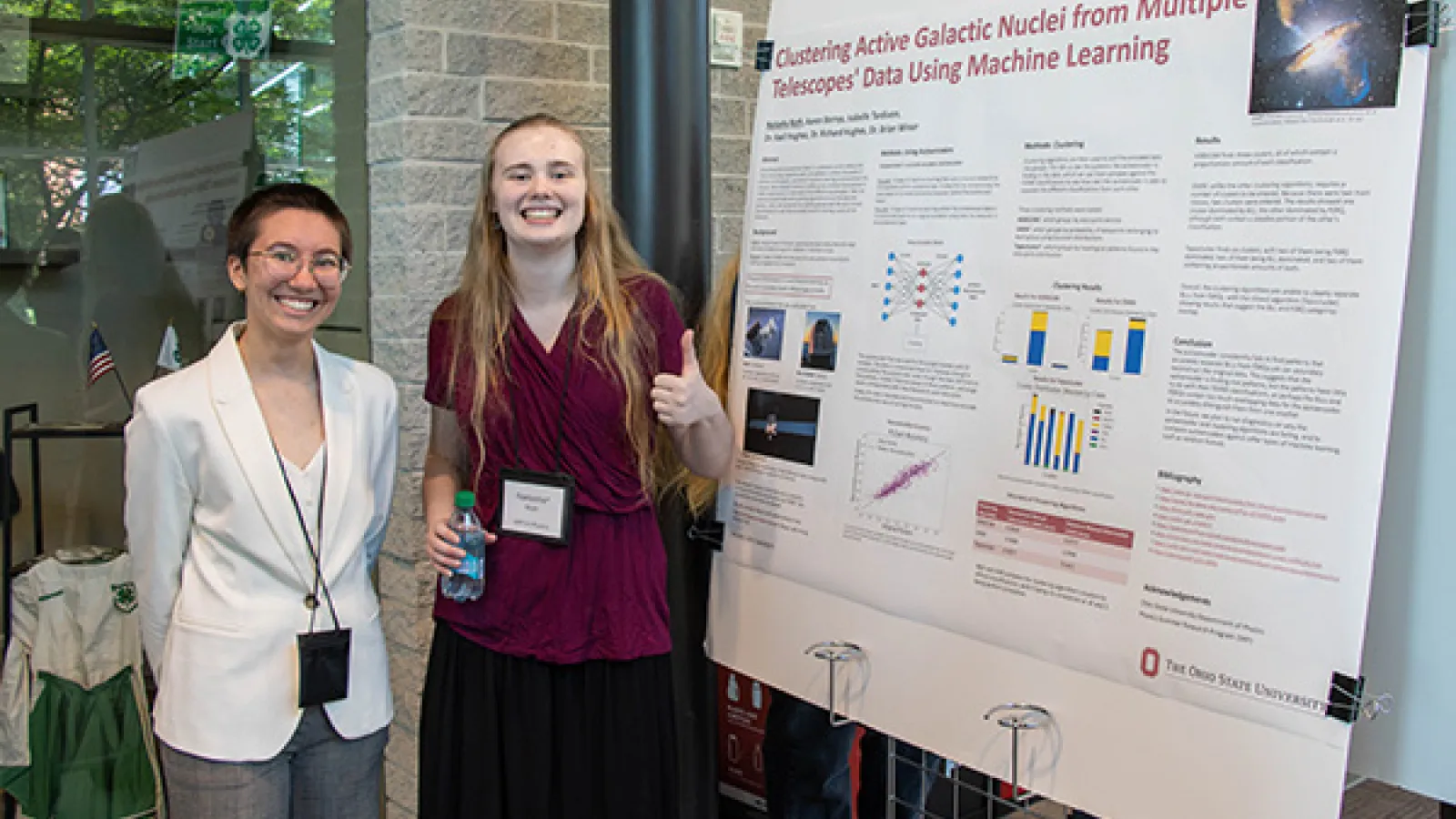Two girls smiling in front of poster presentation 