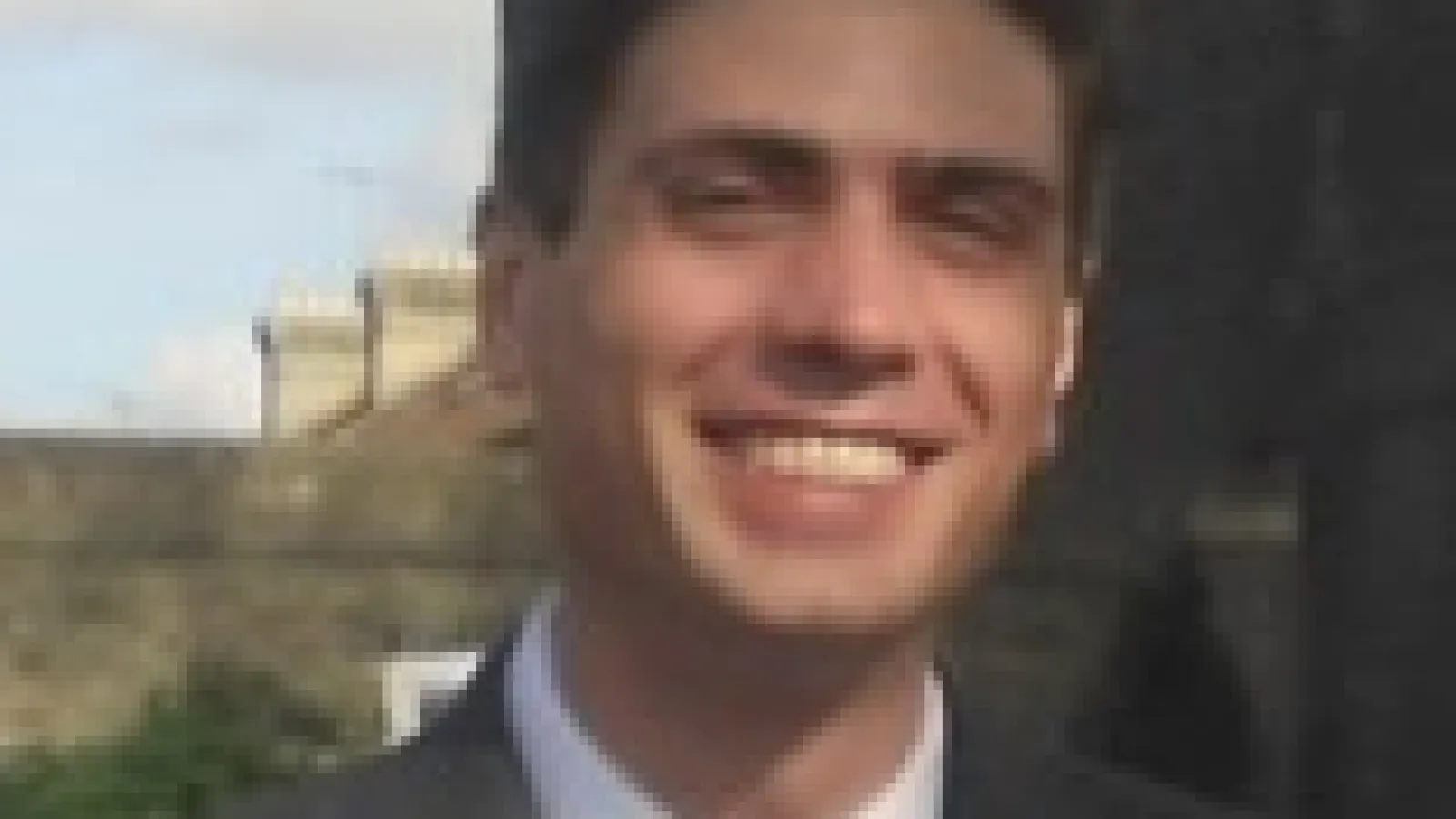Antonio Boveia in suit with blurry structure behind him