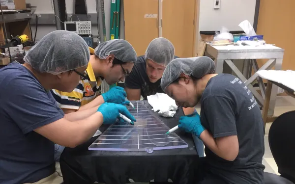 Photo of mike lisa students in lab with STAR detector