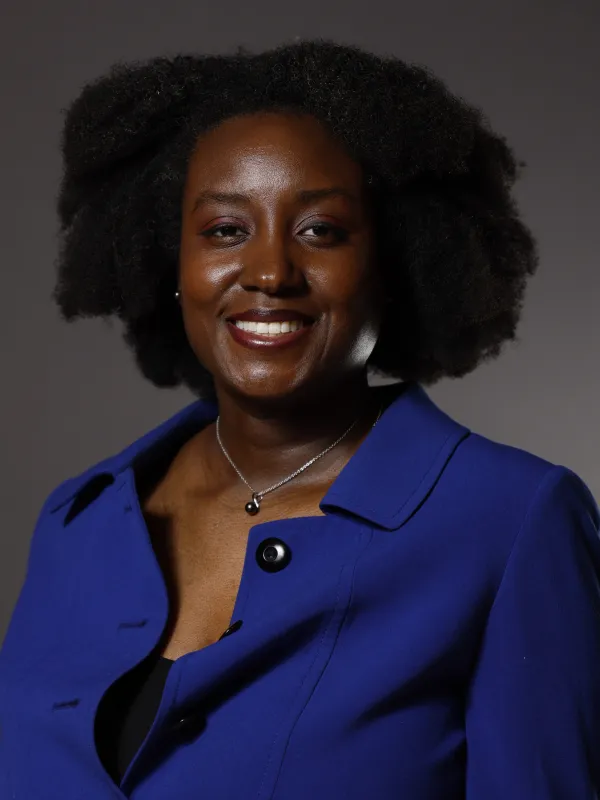 Professor Geraldine Cochran in blue blazer with plain grey background