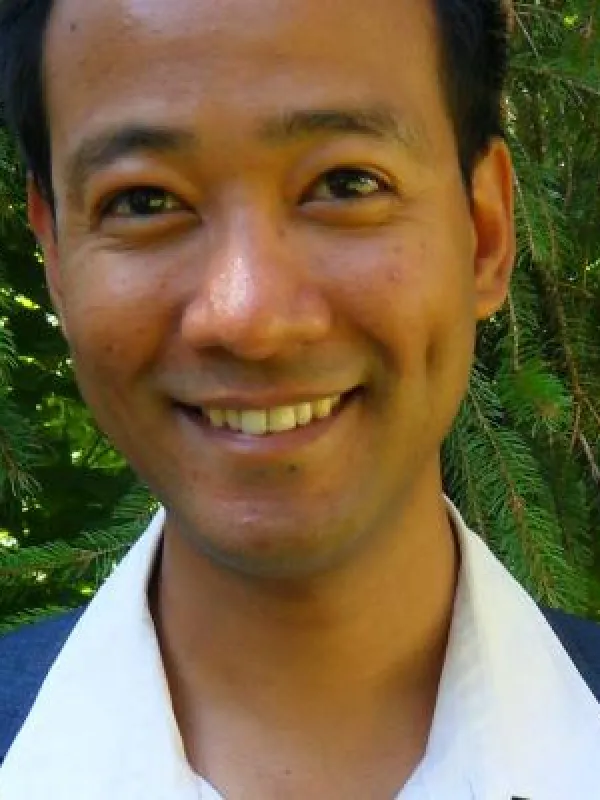Suyog smiling with pine tree behind him