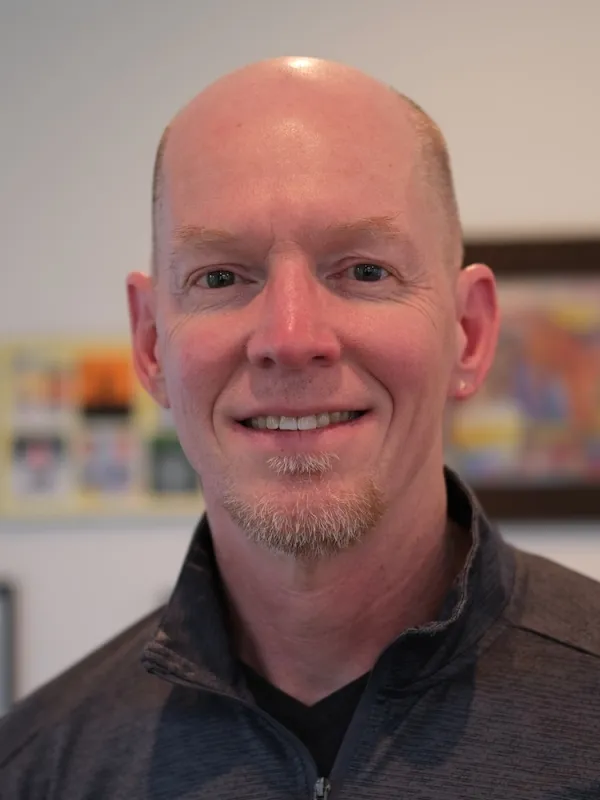 Richard Hughes smiling with blurred background