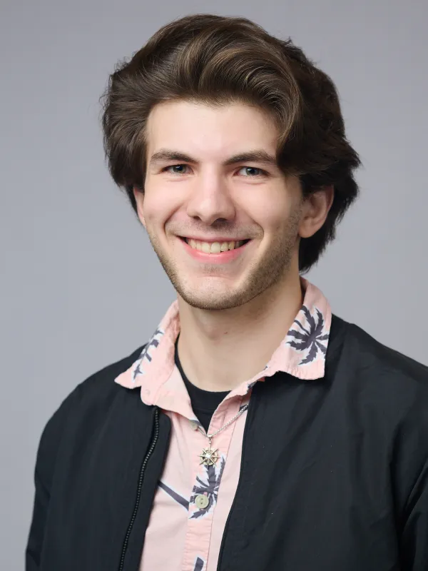 Reilly smiling in front of a grey background