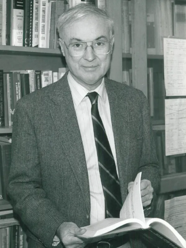 David Edwards in a library holding a book.