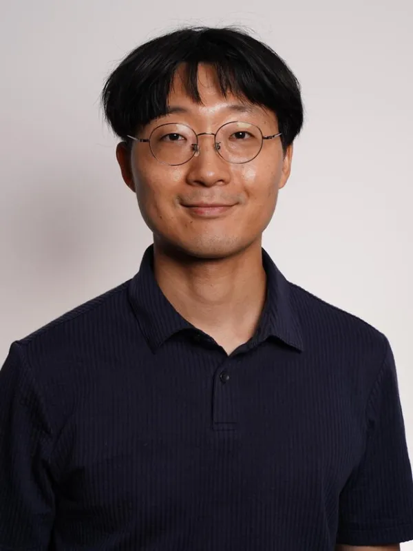 Close up of Youngseok smiling with a neutral background