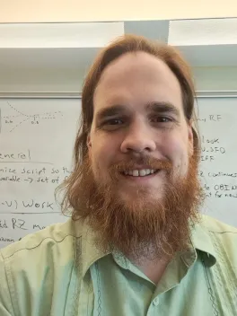 Headshot of Ashley Ross with class whiteboard in the background